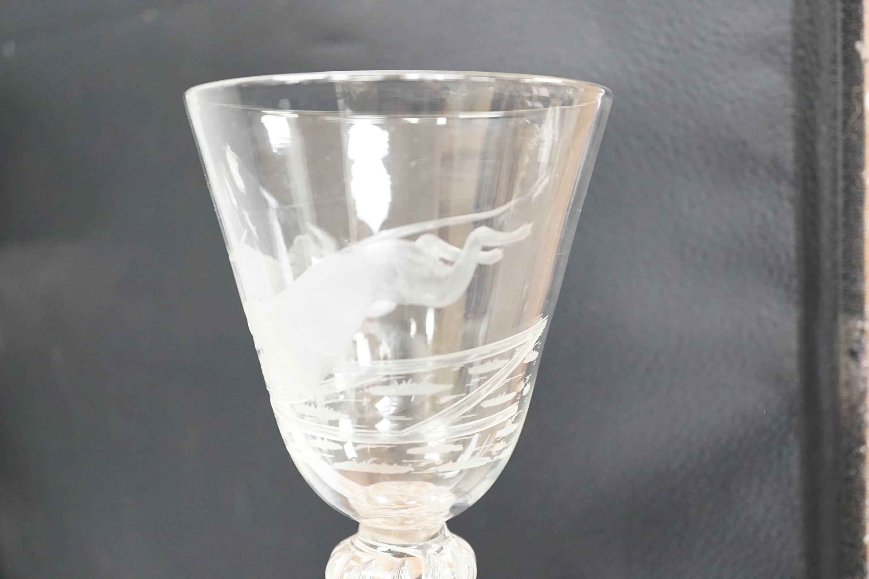 An English lead crystal mammoth trophy goblet, 19th century / early 20th century, engraved with two racing greyhounds, coats numbered 1 and 2, leaping a hurdle, four knopped multiple teared stem and a wide foot with brok